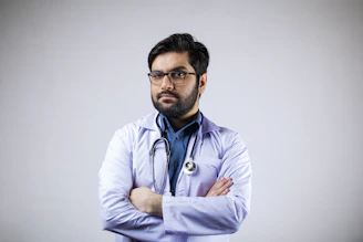 Portrait of a confident doctor in a white coat with a stethoscope, standing in a well-lit medical office.