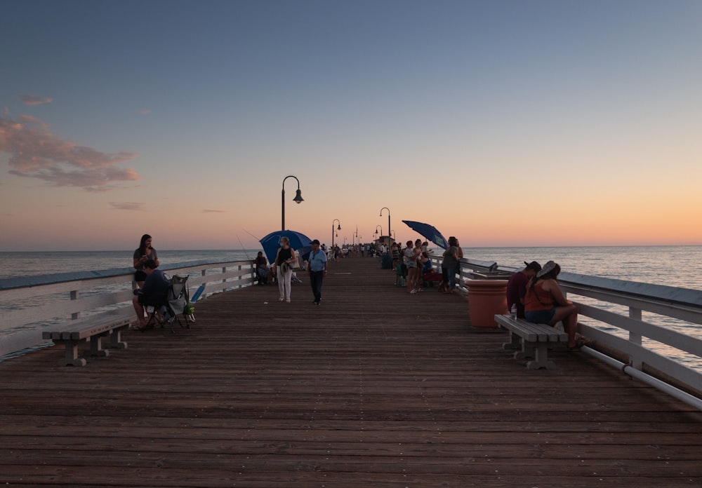 people sitting on bench near sea during daytime