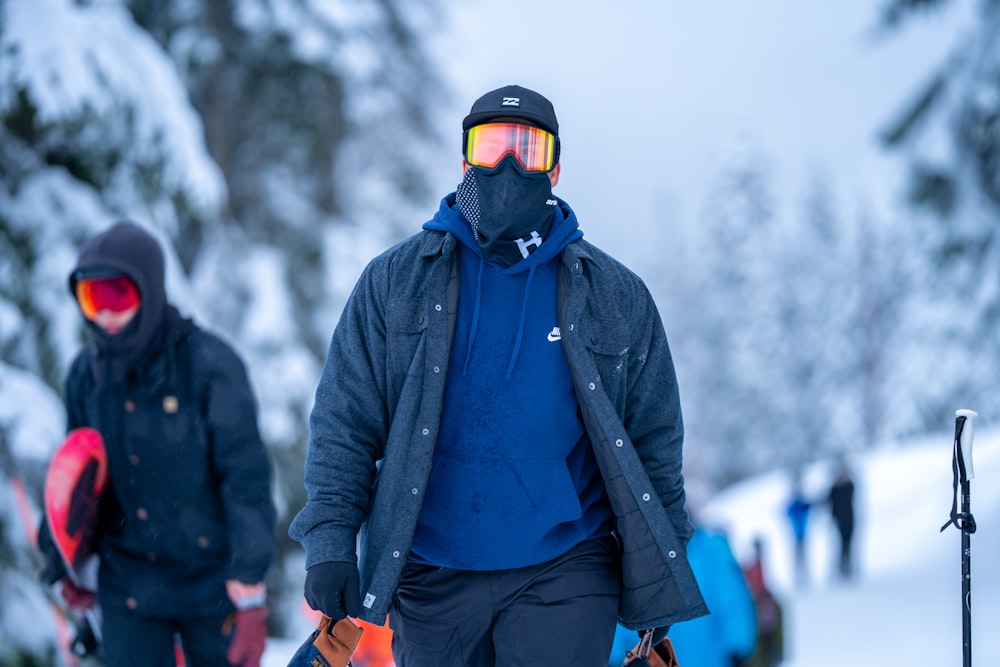 man in black jacket and blue pants wearing black goggles