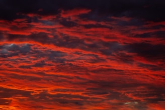 Clouds streaked with fiery red hues stretching across the horizon.