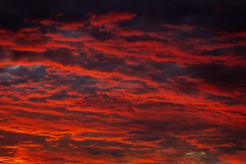 Clouds streaked with fiery red hues stretching across the horizon.