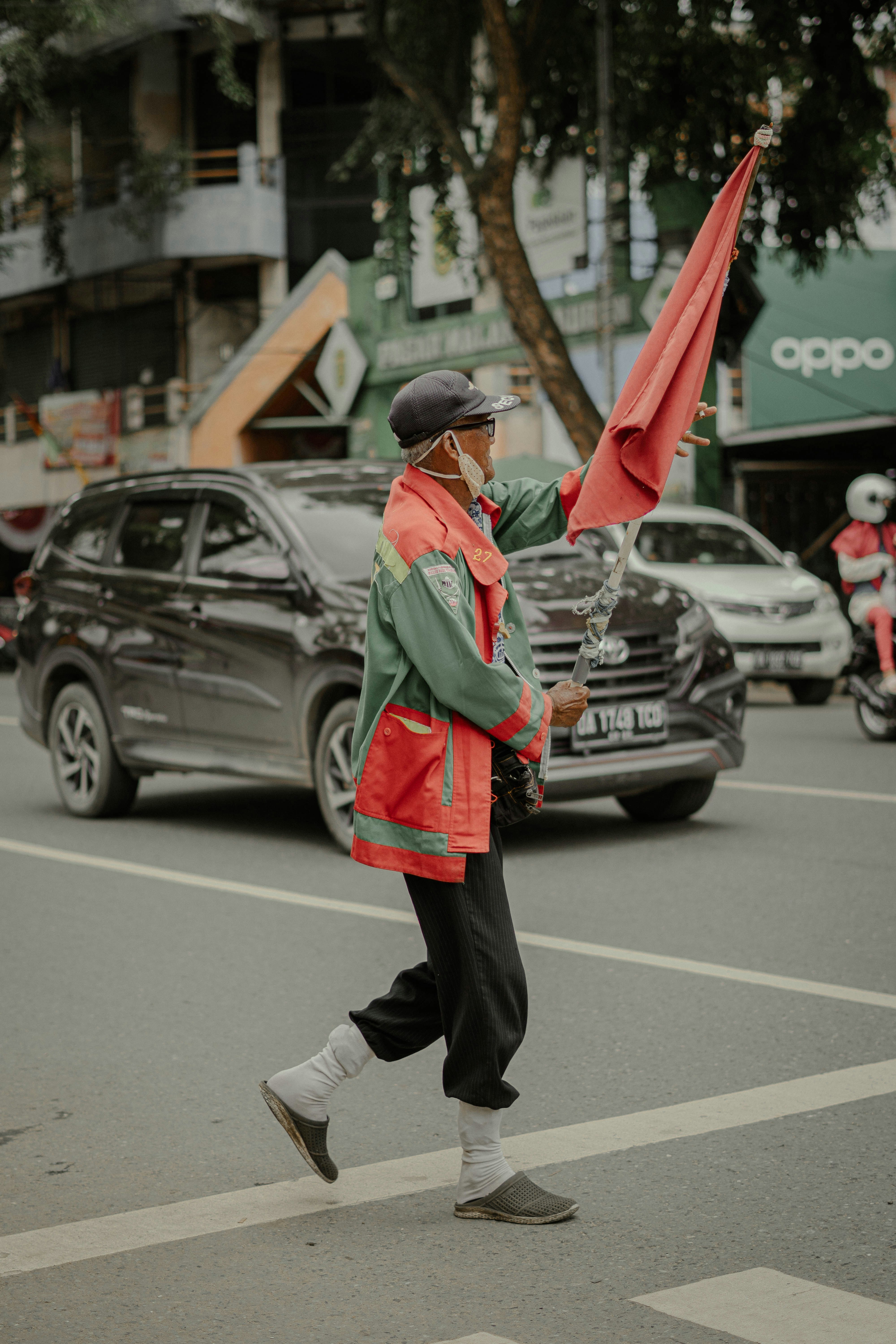 woman in green jacket and black pants walking on street during daytime
