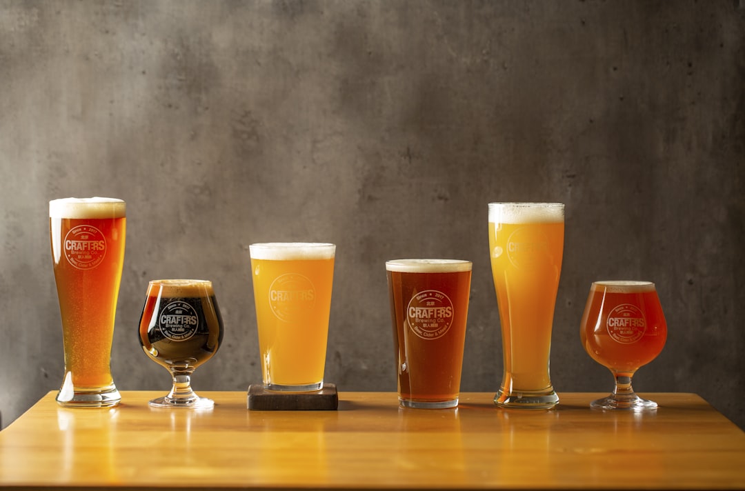 three clear drinking glasses on brown wooden table, Full range of 6 beers by Crafters Brewing