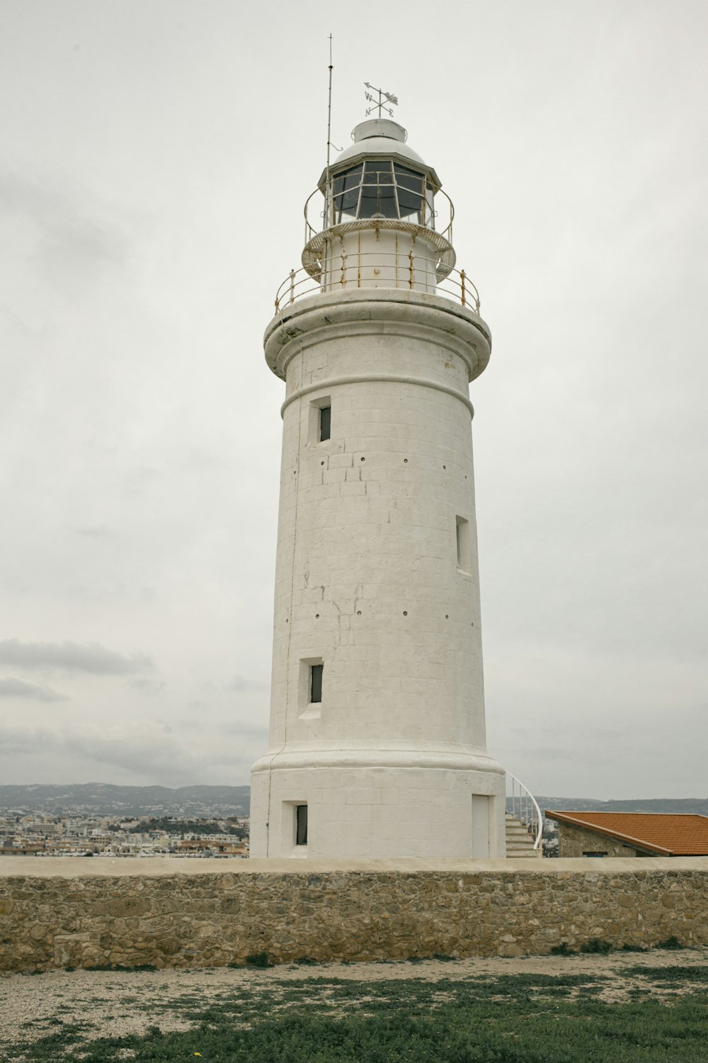 white concrete lighthouse under white clouds during daytime