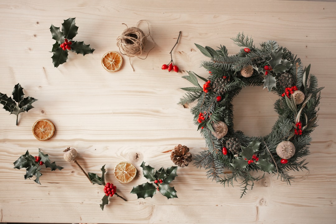 green and red wreath on white wooden wall