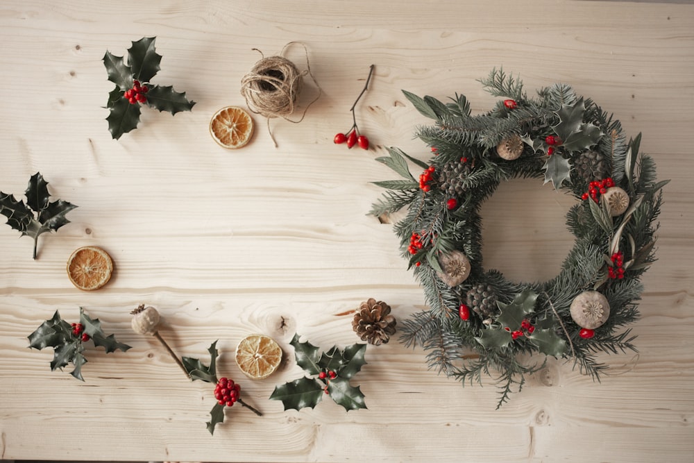 green and red wreath on white wooden wall