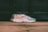 A pair of stylish sneakers with a colorful design, including shades of green, yellow, purple, and white. The sneakers are positioned on a wooden surface with a blurred background, creating a sense of motion.