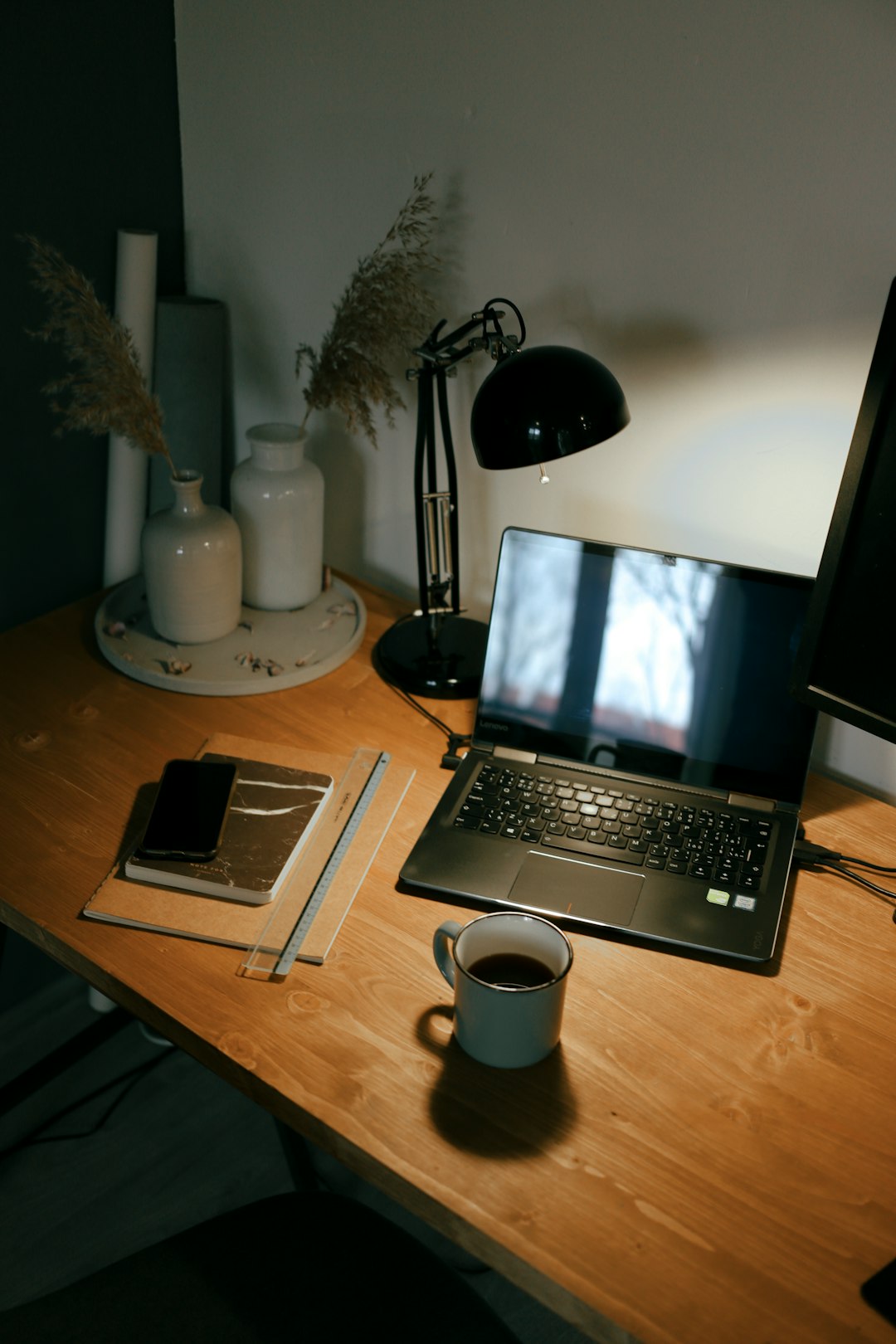 black laptop computer beside white ceramic mug on brown wooden table