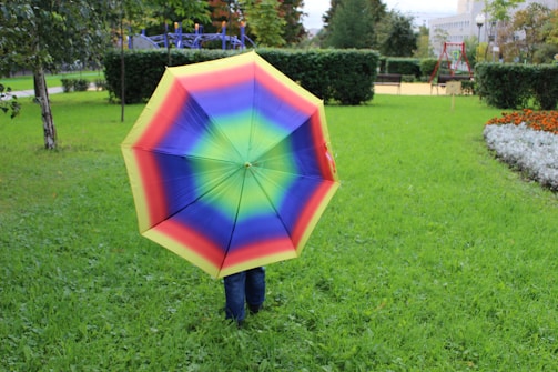 Colorful playful parachute with children holding edges in a sunny park.