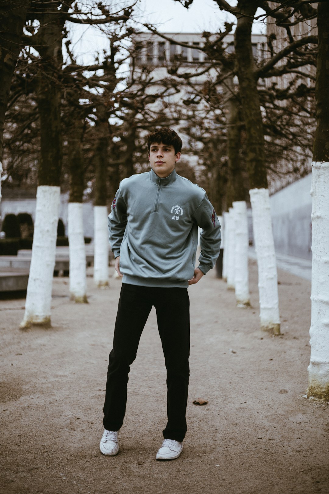 man in gray and black adidas hoodie standing on gray concrete road during daytime