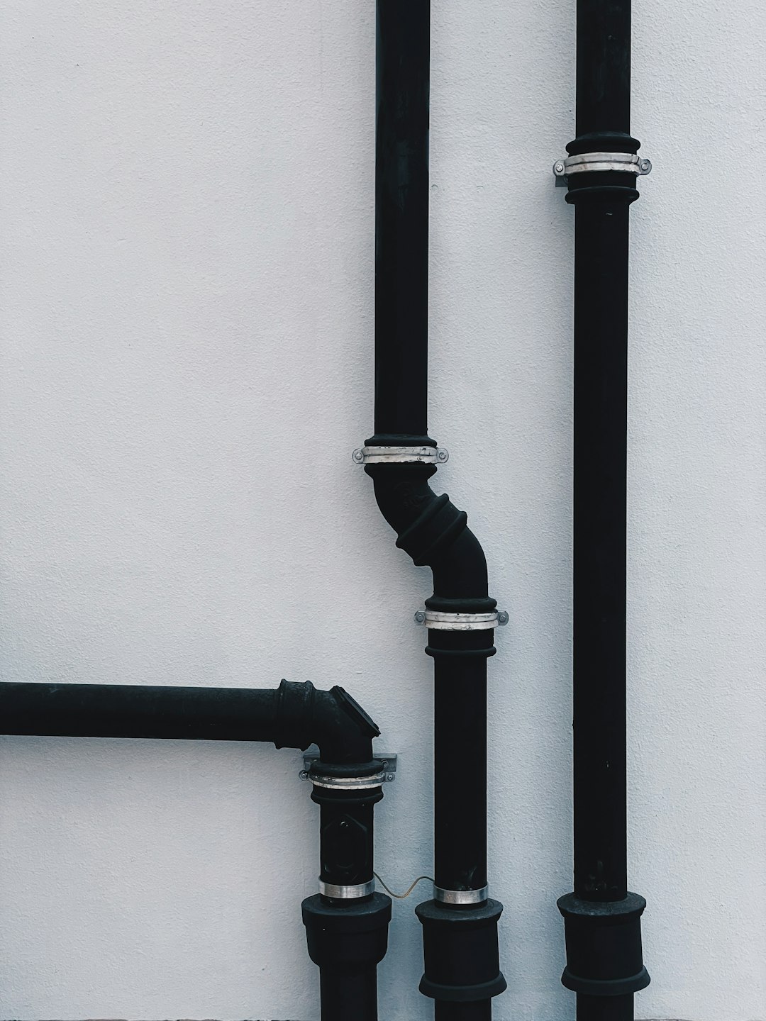 black metal pipe on white wall