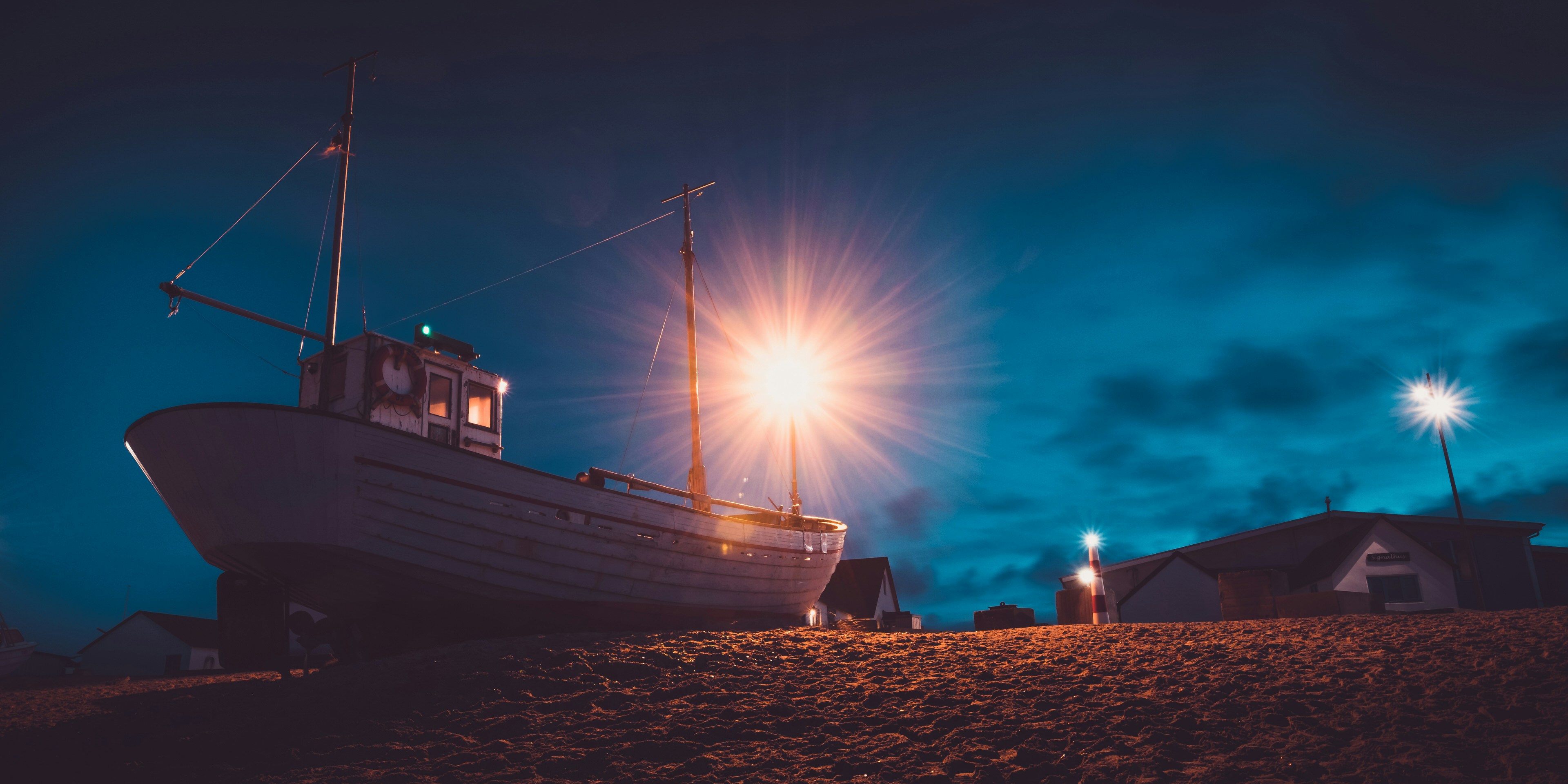 weißes und schwarzes Boot tagsüber am Strand
