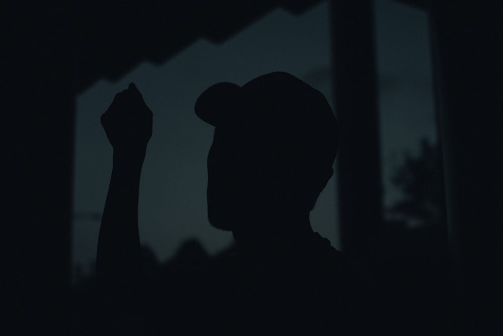 silhouette of man wearing cap