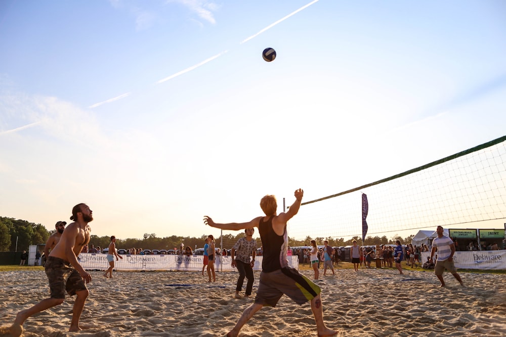 a group of people on a beach playing volleyball