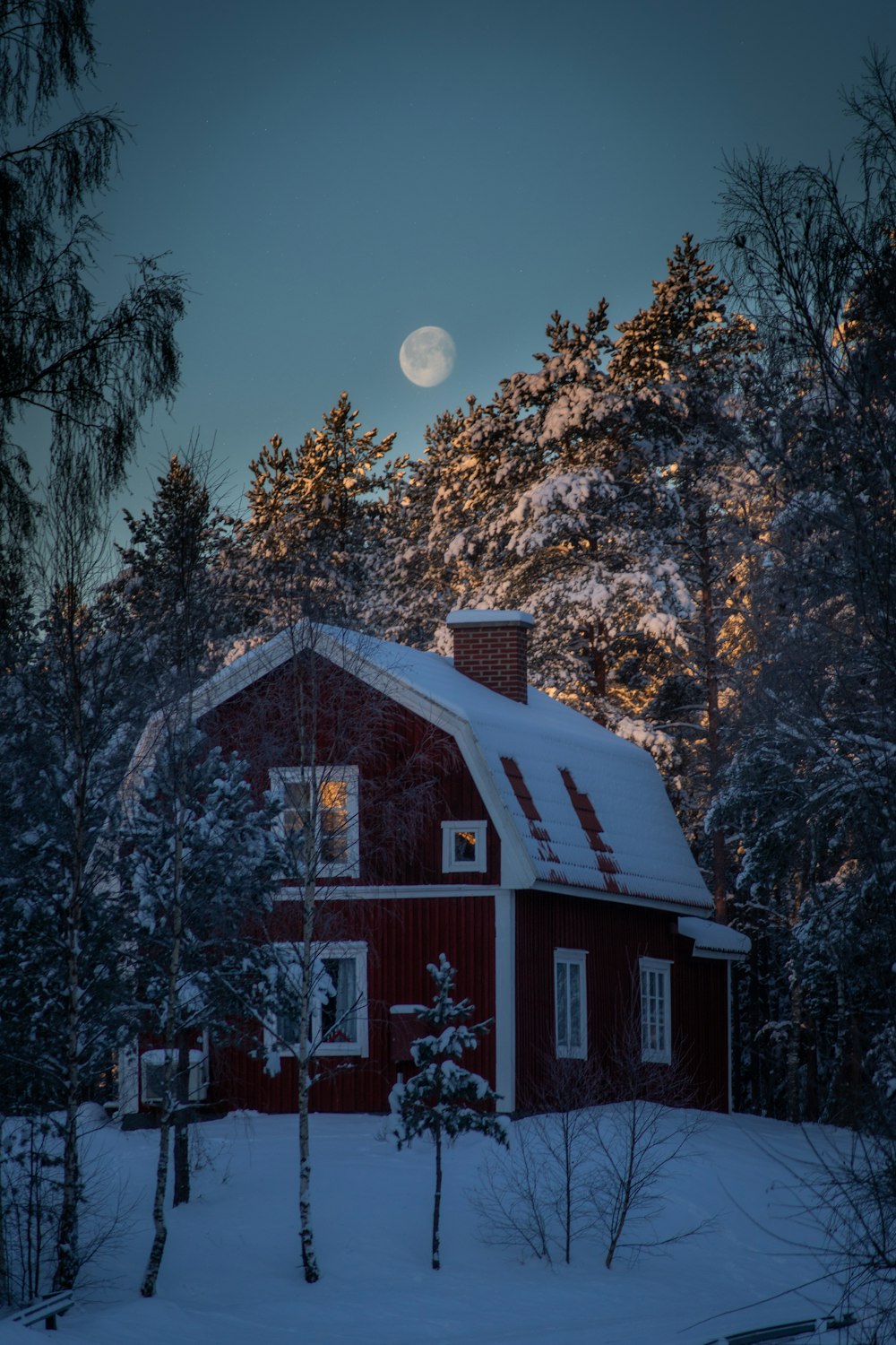 brown and white wooden house near trees under blue sky during night time