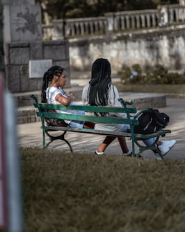 woman in black jacket sitting on blue bench