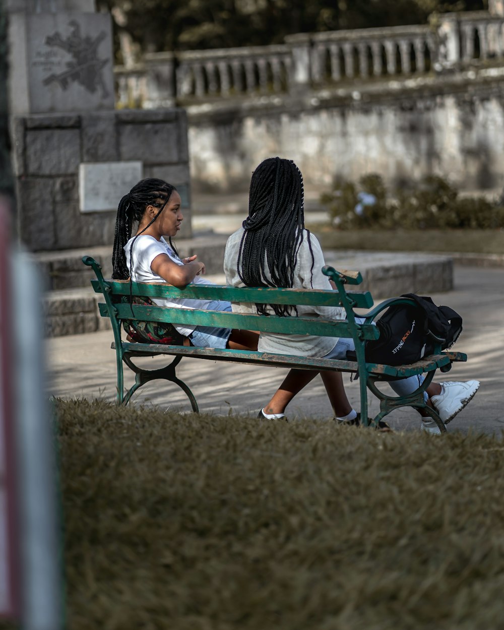 woman in black jacket sitting on blue bench