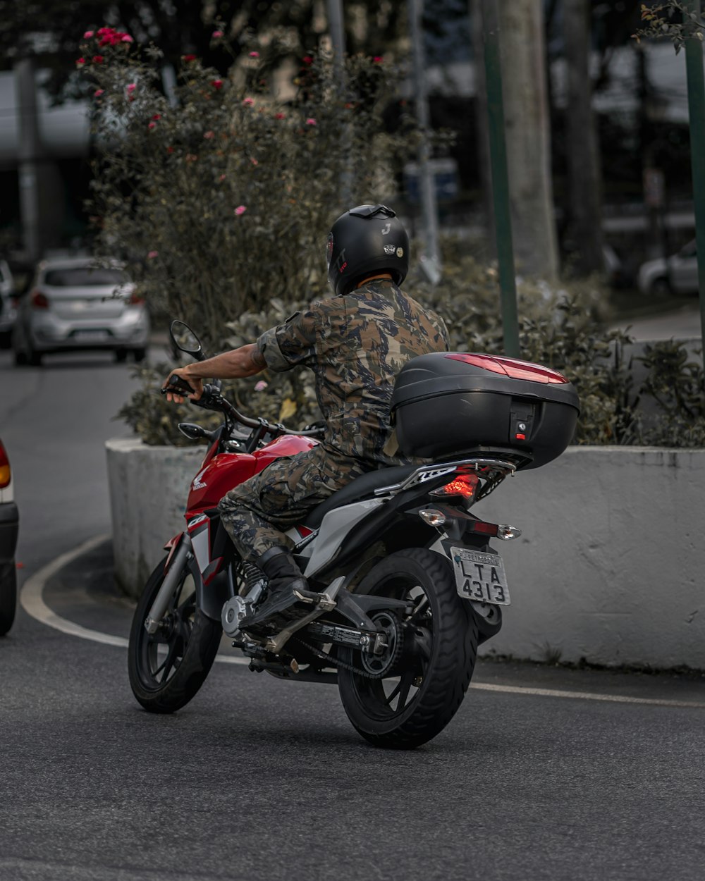 Mann in schwarzem Helm auf schwarz-rotem Motorrad