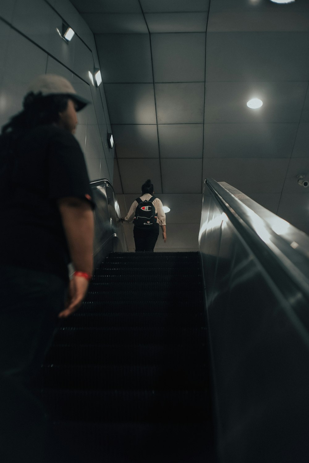 man in black t-shirt standing on escalator