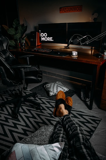 A cozy room with a webcam setup showing a lively chat interface and a performer smiling warmly.