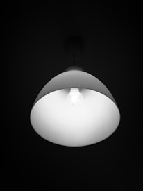 Close-up of a minimalist, handcrafted lighting detail in matte black and cream tones.