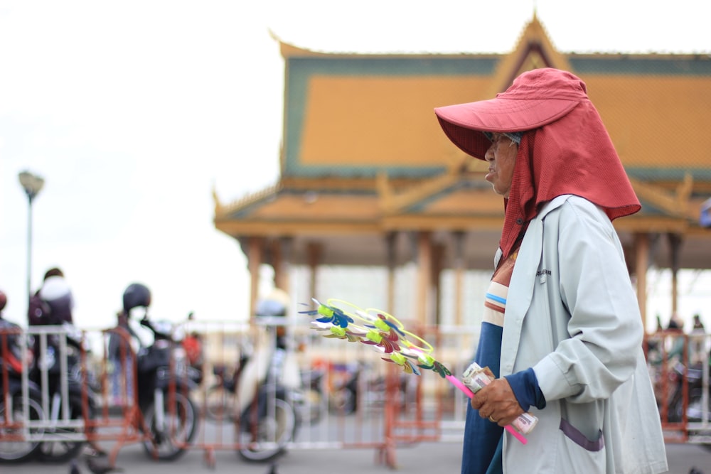 man in white long sleeve shirt and brown hat holding white and green plastic umbrella during