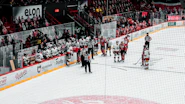 A lively group of adult hockey players sharing laughs on the ice rink.