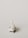 A miniature figurine of a nurse stands beside a hospital bed with a patient lying under a white blanket. The scene is minimalist with a pale background, emphasizing the medical figures.