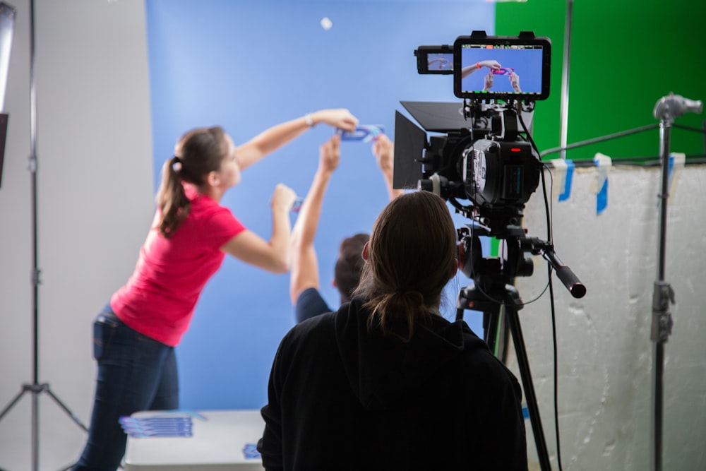 woman in pink long sleeve shirt holding black video camera