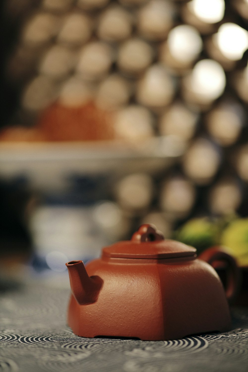 red ceramic teapot on blue table