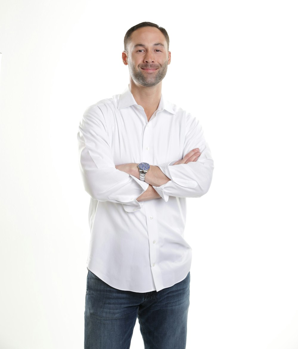 man in white dress shirt and blue denim jeans