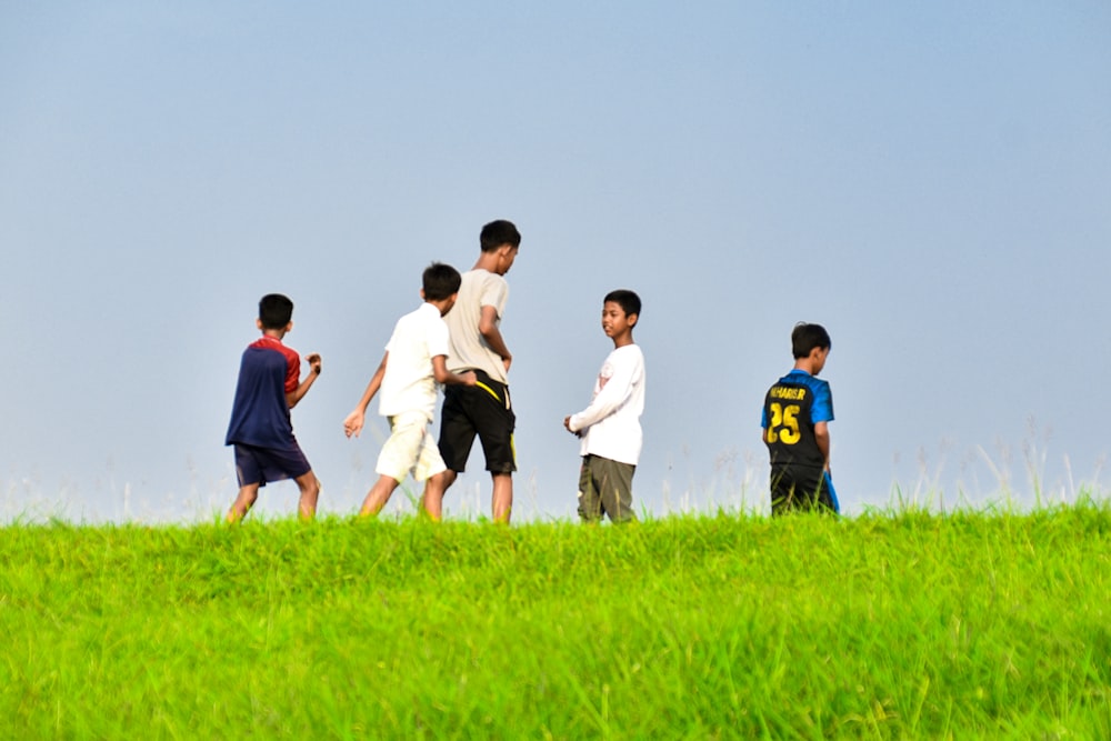 group of people standing on green grass field during daytime