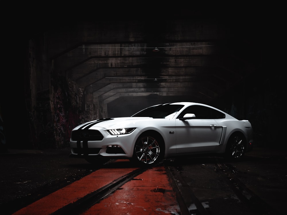 a white car parked in a dark tunnel