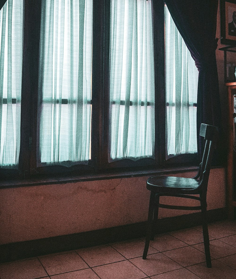chaise en bois marron près de la fenêtre
