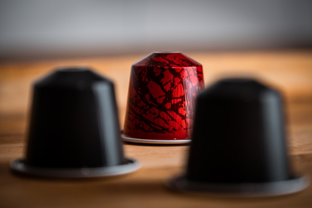 red and black round container on brown wooden table