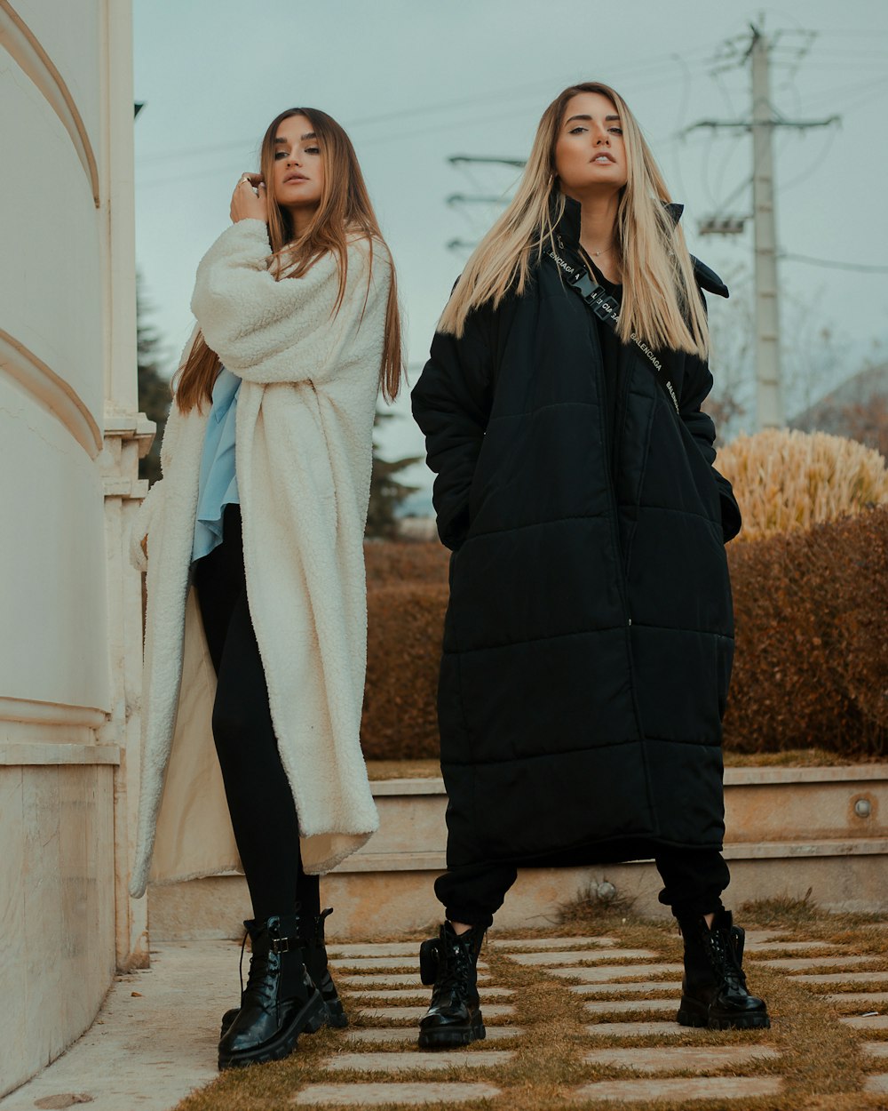 woman in black coat standing beside woman in white coat