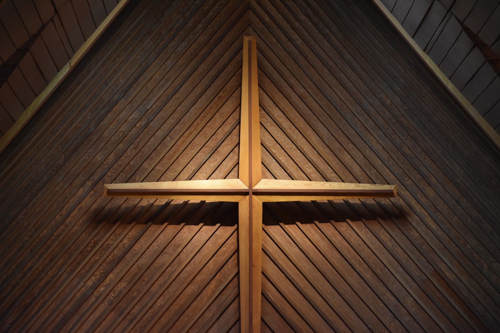 cruz de madeira marrom na parede de madeira marrom