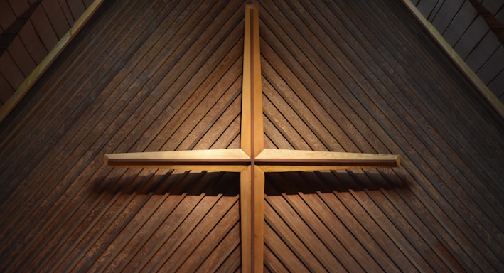 brown wooden cross on brown wooden wall