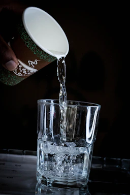 Close-up of fresh, crystal-clear alkaline water being poured into a reusable bottle.