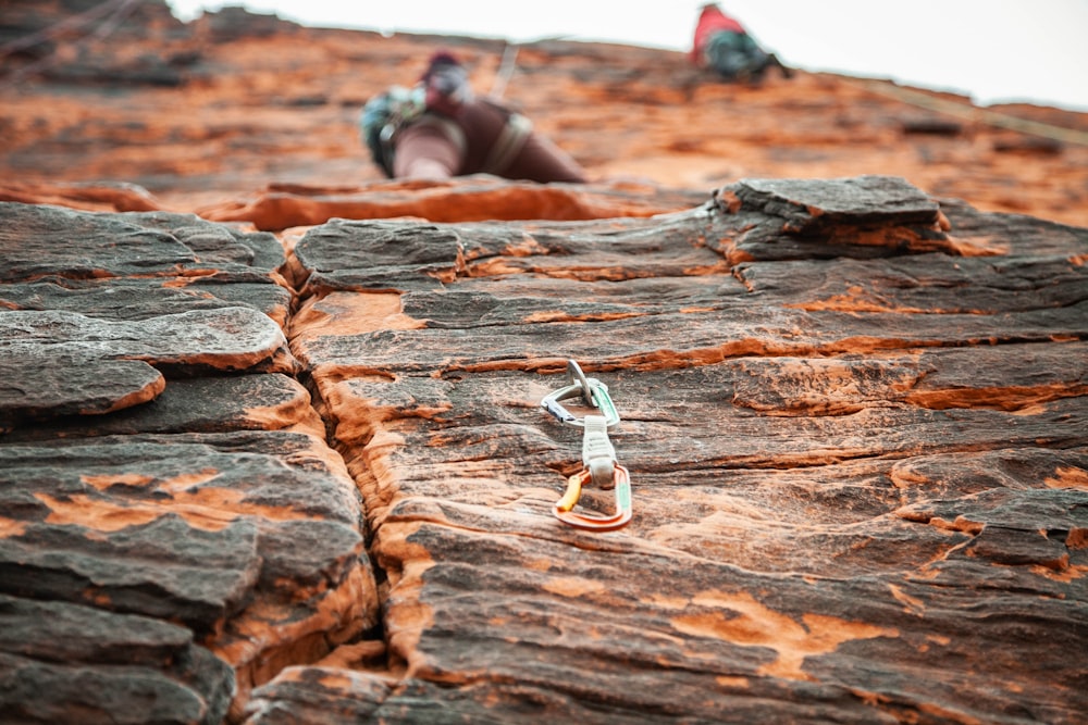 person in black and white shoes lying on brown rock during daytime