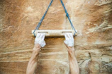 Close-up of hands gripping a rock climbing hold on a textured wall