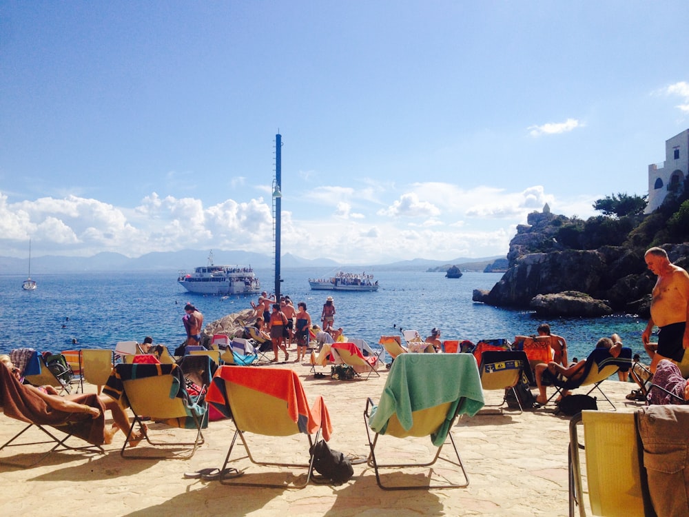 people sitting on chairs on beach during daytime