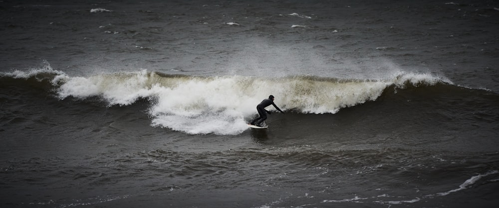 man surfing on sea waves during daytime