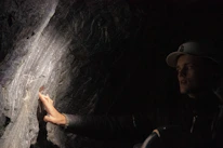 Close-up of hands inspecting mineral samples under bright light.