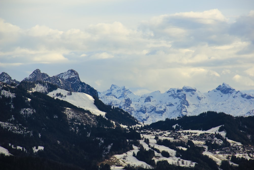 snow covered mountains under cloudy sky during daytime