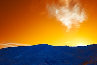 A vibrant landscape photograph showcasing mountains and a sunset.