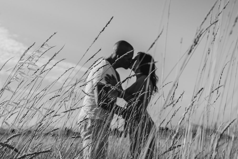grayscale photo of man and woman kissing
