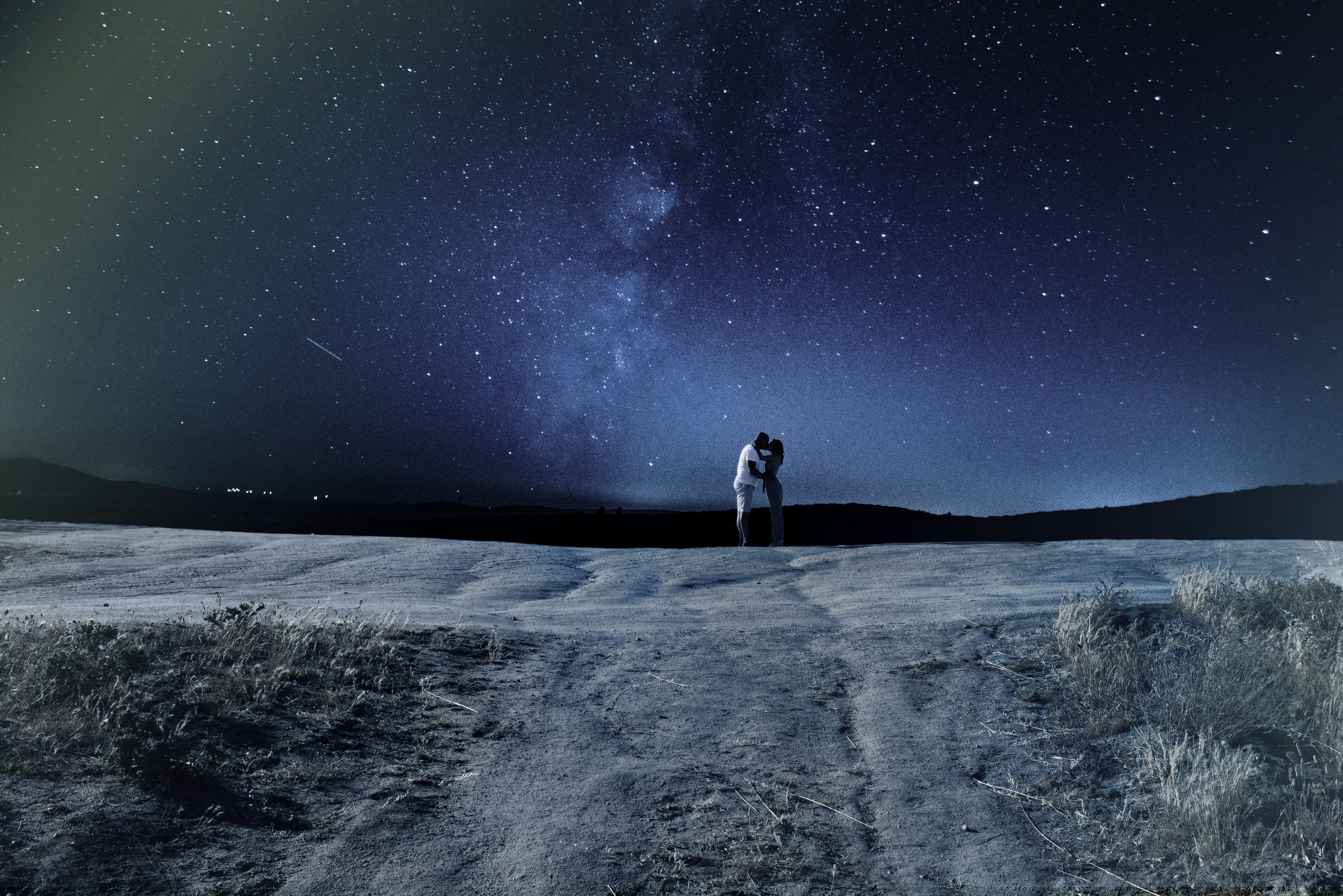 man in black jacket and black pants standing on white sand during daytime