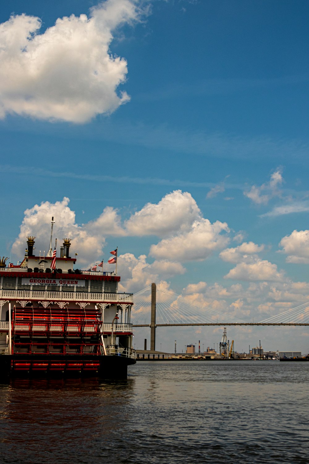 rot-weißes Schiff auf See unter blauem Himmel und weißen Wolken tagsüber