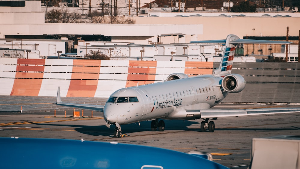 white and blue passenger plane on airport during daytime